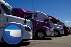 oklahoma map icon and row of semi trucks at a truck dealership