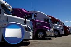 south-dakota map icon and row of semi trucks at a truck dealership