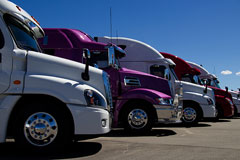 row of semi trucks at a truck dealership