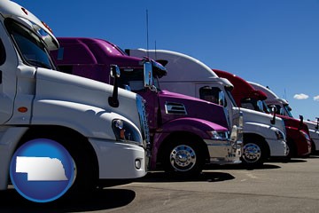 row of semi trucks at a truck dealership - with Nebraska icon