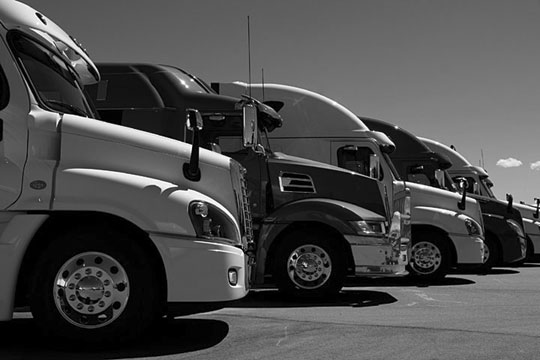 row of semi trucks at a truck dealership