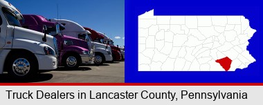 row of semi trucks at a truck dealership; Lancaster County highlighted in red on a map