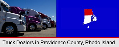 row of semi trucks at a truck dealership; Providence County highlighted in red on a map