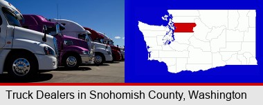 row of semi trucks at a truck dealership; Snohomish County highlighted in red on a map