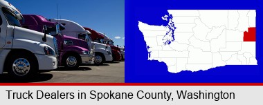 row of semi trucks at a truck dealership; Spokane County highlighted in red on a map